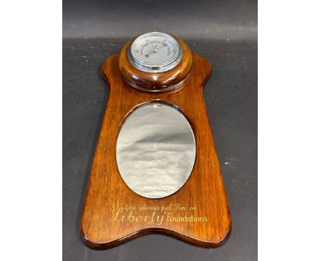 A mahogany wall hanging combined barometer and wall mirror bearing advertising for Liberty Foundations, 8 x 15 1/2".