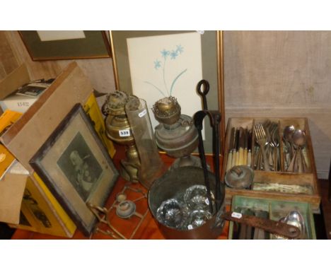 Two brass oil lamps, two trays of cutlery, a Victorian copper saucepan, boxed projector etc