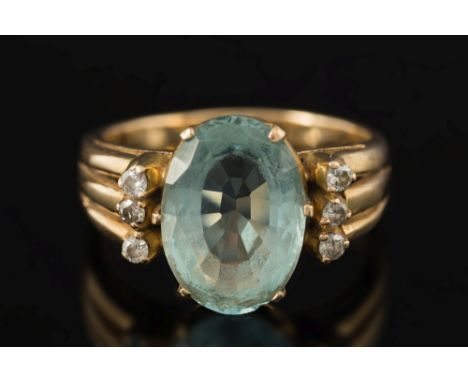 An aquamarine and diamond ring:, the central, oval aquamarine approximately 14mm long x 10mm wide, between circular diamond, 