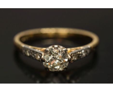 A diamond single-stone ring: the round old brilliant-cut stone approximately 0.55ct, between diamond-set two-stone shoulders,