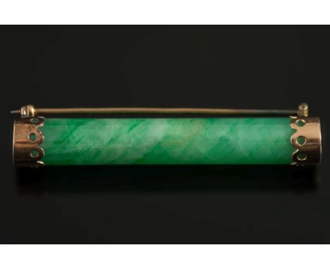 A cylindrical green jade rod mounted bar brooch:, 47mm long overall.

(Jade not tested for natural colour or enhancements)