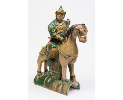 A Chinese 'sancai' glazed pottery roof tile: in the form of an equestrian warrior, decorated in lead glazed amber, green and 