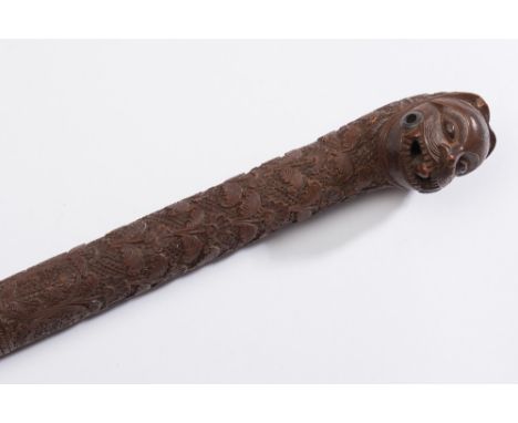 An Indian carved hardwood walking stick: with carved spiral twist carved decoration of animals, serpents and birds, the pomme