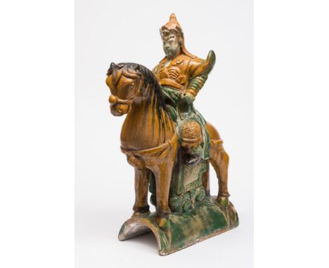 A Chinese 'sancai' glazed pottery roof tile: in the form of an equestrian warrior, decorated in lead glazed amber, green and 