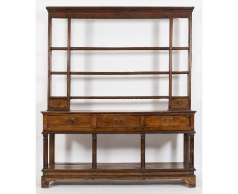 An early 19th Century oak dresser:, the shelved superstructure with a moulded cornice, the base fitted with three frieze draw