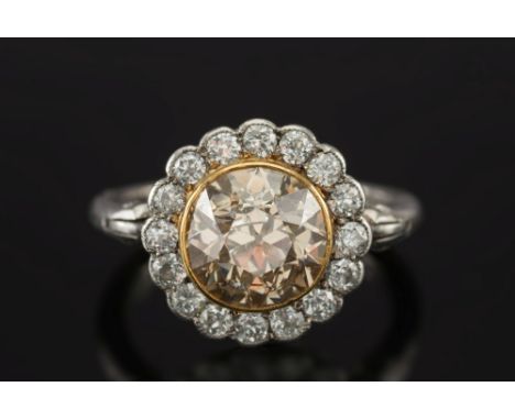 A yellowish brown diamond and diamond circular cluster ring:, the central yellowish brown diamond (not tested for natural col