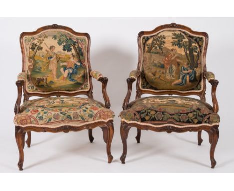 A pair of 18th Century French carved walnut and tapestry upholstered fauteuils:, the moulded cartouche shaped backs with flow