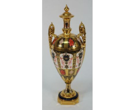 A Royal Crown Derby two-handled porcelain pedestal urn: of slender oviform with up-scrolled handles richly decorated in the I