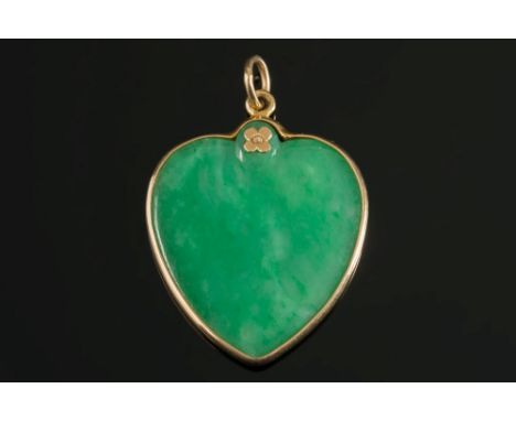 A heart shaped green jade pendant:, the green jade panel 29mm diameter within a 'spectacle frame' setting with suspension loo