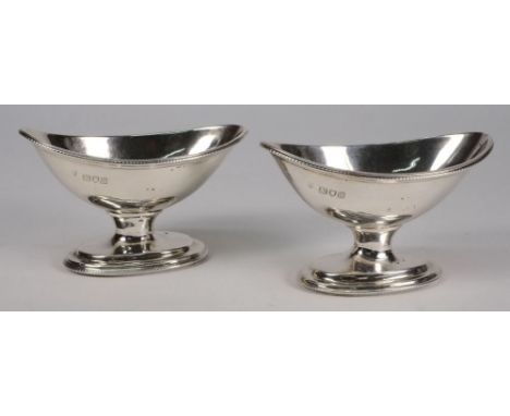 A pair of George V silver pedestal salts, maker CS Harris and Sons, London, 1913: of oval outline with beaded borders raised 