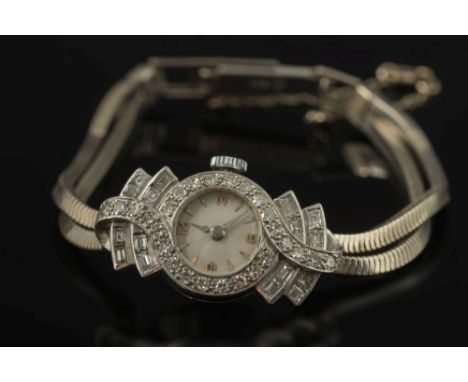 A lady's diamond mounted cocktail wristwatch:, the circular dial with baton markers and Arabic numerals, within a surround of