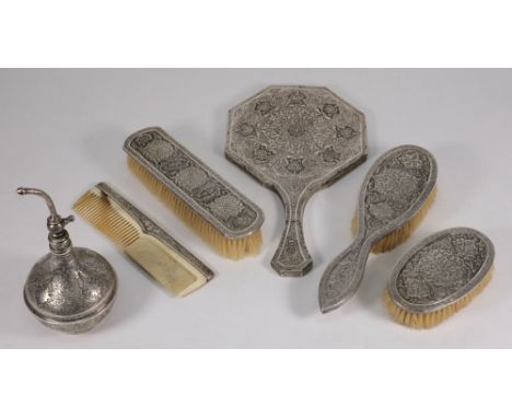 A Persian silver dressing table set: with all over foliate decoration, includes brushes, perfume atomiser, comb and mirror.