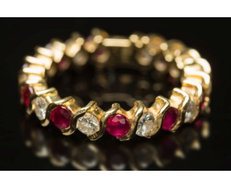 A modern, ruby and diamond eternity ring: with circular stones set alternately, the diamonds estimated to weigh a total of 0.