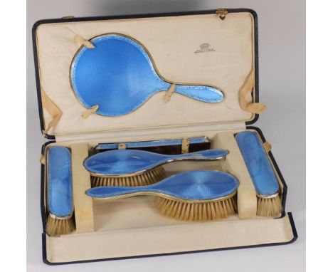 A George V silver and blue enamel dressing table set, maker C&RC, London, 1925: includes hand mirror, two hair brushes, two c