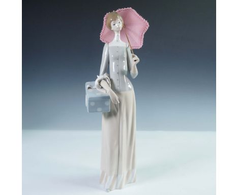 Lladro porcelain figurine number 4700 titled Dressmaker, depicting an elegant woman in a long cream-colored skirt and tailore