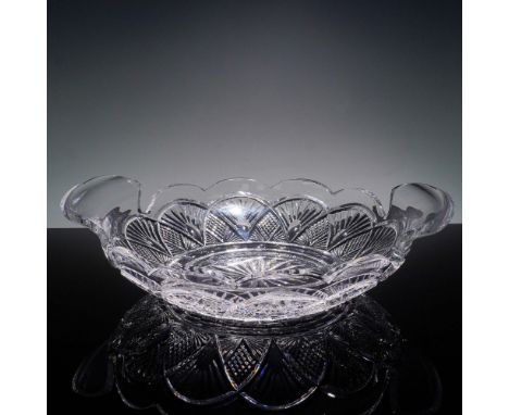 This elegantly cut crystal centerpiece bowl from Waterford showcases a scalloped rim and sweeping fan and cross-hatch pattern