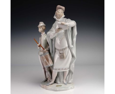 This elegant Lladro porcelain figurine, model 01001086, titled Pregonero, captures a street crier accompanied by a young drum