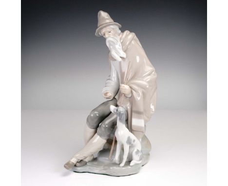 Handcrafted in Spain by Lladro, this porcelain figurine titled Beggar with Dog (item 01001094) features a solemn bearded man 