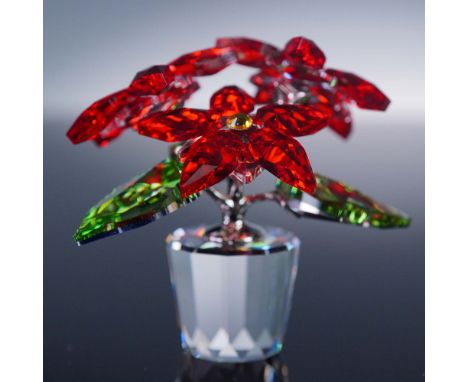 This Swarovski crystal poinsettia figurine captures the holiday spirit with vivid red crystal petals, sparkling green leaves,
