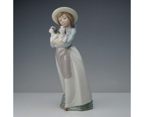 This charming Lladro NAO porcelain figurine, handcrafted in Spain in 1991, titled What an Armful, depicts a young girl wearin