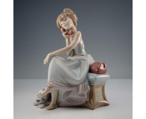 Seated girl talking on a telephone with a spotted dog laying besides her. Glazed finish. Lladro backstamp. This item has its 