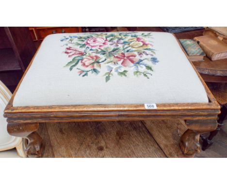 An oak framed stool on claw and ball feet with tapestry upholstered seat 