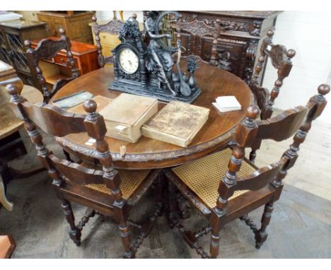 A circular Breton carved oak dining table on a heavy pillar and quadruple base together with six similar ladder back style di