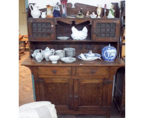 An oak Arts & Crafts style dresser cupboards and drawers under shelf back with glazed doors 45cms wide x 74cms high 