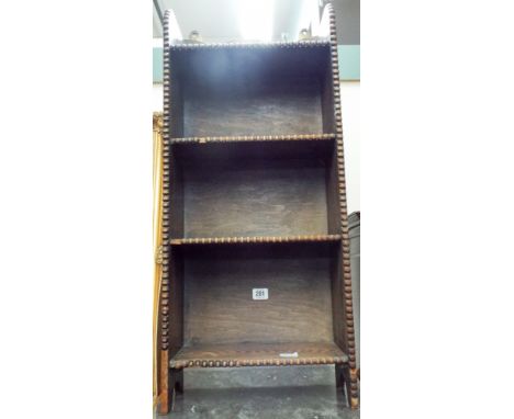 A narrow oak three shelf bookcase decorated with a beaded front 75cms x 33cms