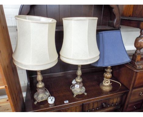 A pair of gilt metal table lamps with shades and one off wooden lamp with blue shade