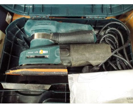 A Black & Decker router, a Black & Decker cordless drill and a Black & Decker sander 