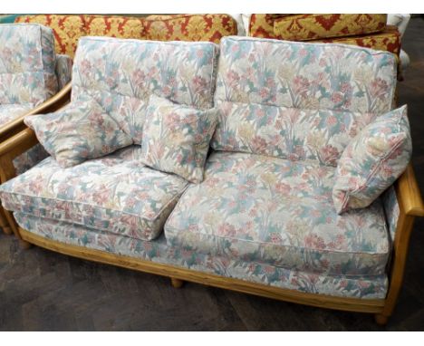 An Ercol three piece lounge suite comprising large two seater sofa, small two seater sofa and matching armchair 