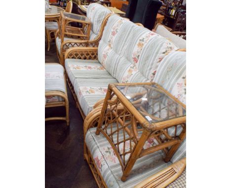 A  three piece bamboo framed conservatory suite, with floral patterned cushions. Including a two seater settee, matching stoo