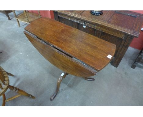 A circular oak drop leaf table on a tripod base, adapted from a George III tilt top table