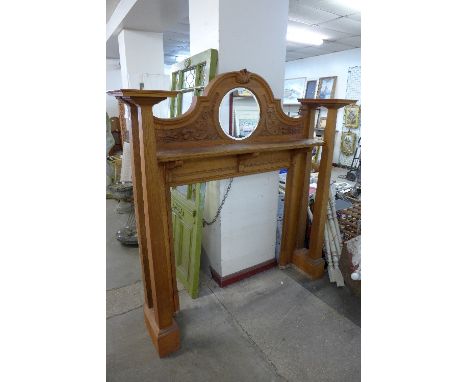 A carved oak architectural style fire surround
