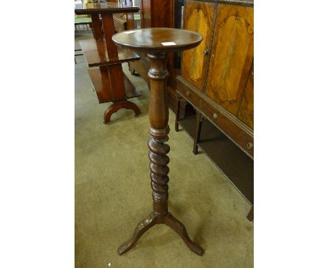 A 20th Century mahogany torchere having a spiral twist column over an acanthus carved tripod base