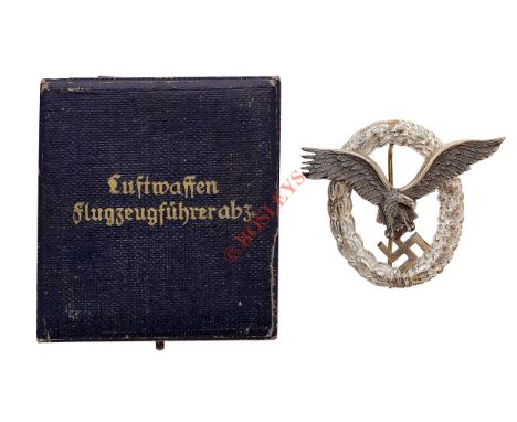 German Third Reich cased WW2 Luftwaffe Pilot’s breast badge. A good die-cast example. Mounted on a silvered oval wreath of la