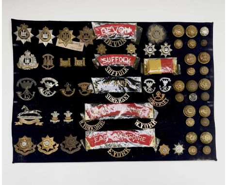 11th - 15th Foot. A display card containing cap badges, collar dogs, shoulder titles and buttons. Noted: Devonshire Regt, Suf