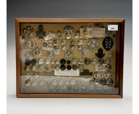 Volunteer Battallions. Comprising a board mounted framed and glazed display of badges, collar dogs, shoulder titles and butto