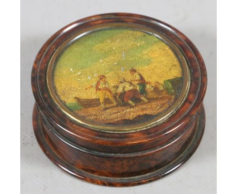 A turned burr walnut snuff box with oil painted lid of sailors loading a boat.