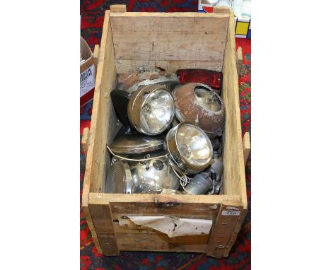 A box of vintage automobile head lamps.