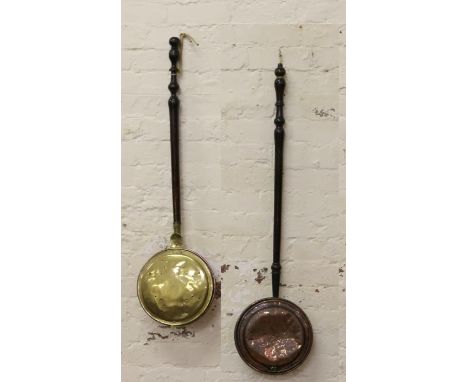 Two Victorian bed warming pans with turned handles, one of brass and the other copper.