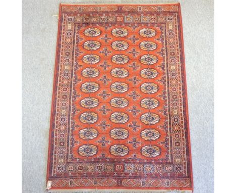A Bokhara style carpet, on a red ground, 200 x 133cm