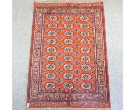 A Bokhara style carpet, on a red ground, 200 x 133cm