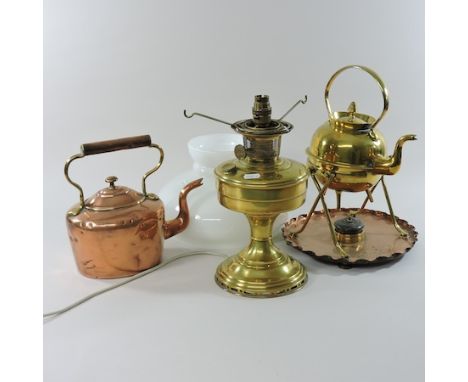 A brass lamp with a white glass shade, together with a brass kettle on a stand, and a copper kettle