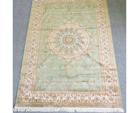 A Keshan style carpet, with a central medallion and floral design, on a green ground, 230 x 150 cm