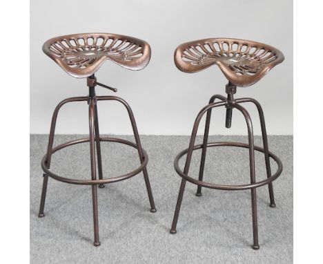 A copper painted metal tractor seat stool, together with another