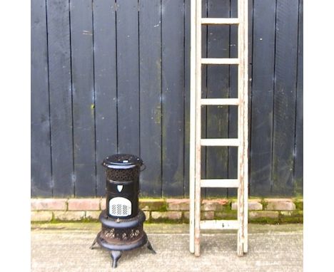 A painted wooden extending ladder, 245cm high, together with a black enamel stove
