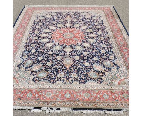 A Persian style woollen carpet, with a central medallion and foliate design, on a blue ground, 370 x 280cm