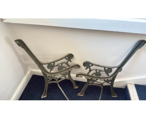 Pair of cast iron garden bench ends with ornate floral design, Victorian style.